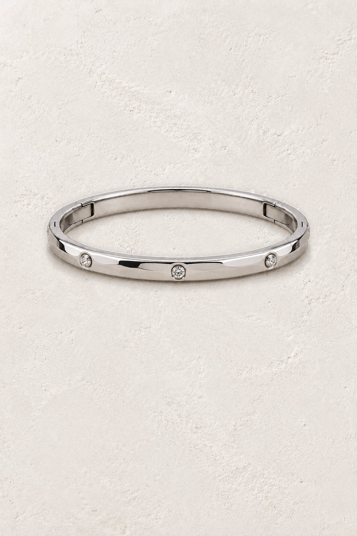 
                  
                    Amelie Silver Crystal Station Bangle on the reference plaster background
                  
                