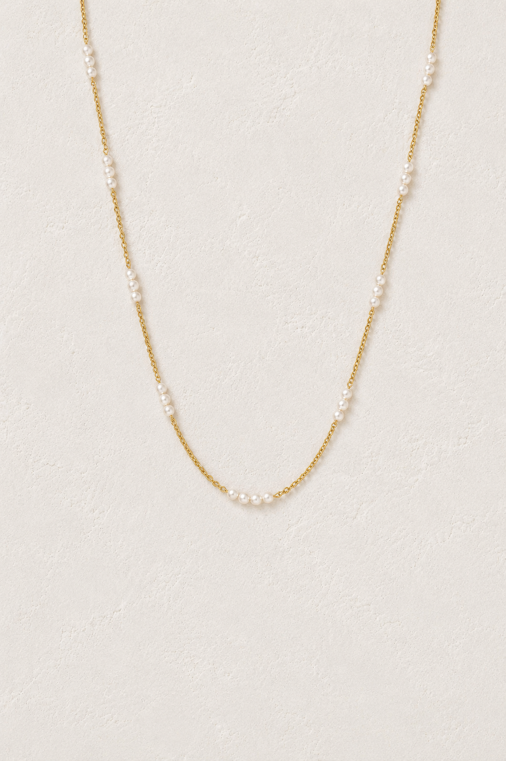 Beaded Freshwater Pearl Chain Necklace in gold on a warm textured background