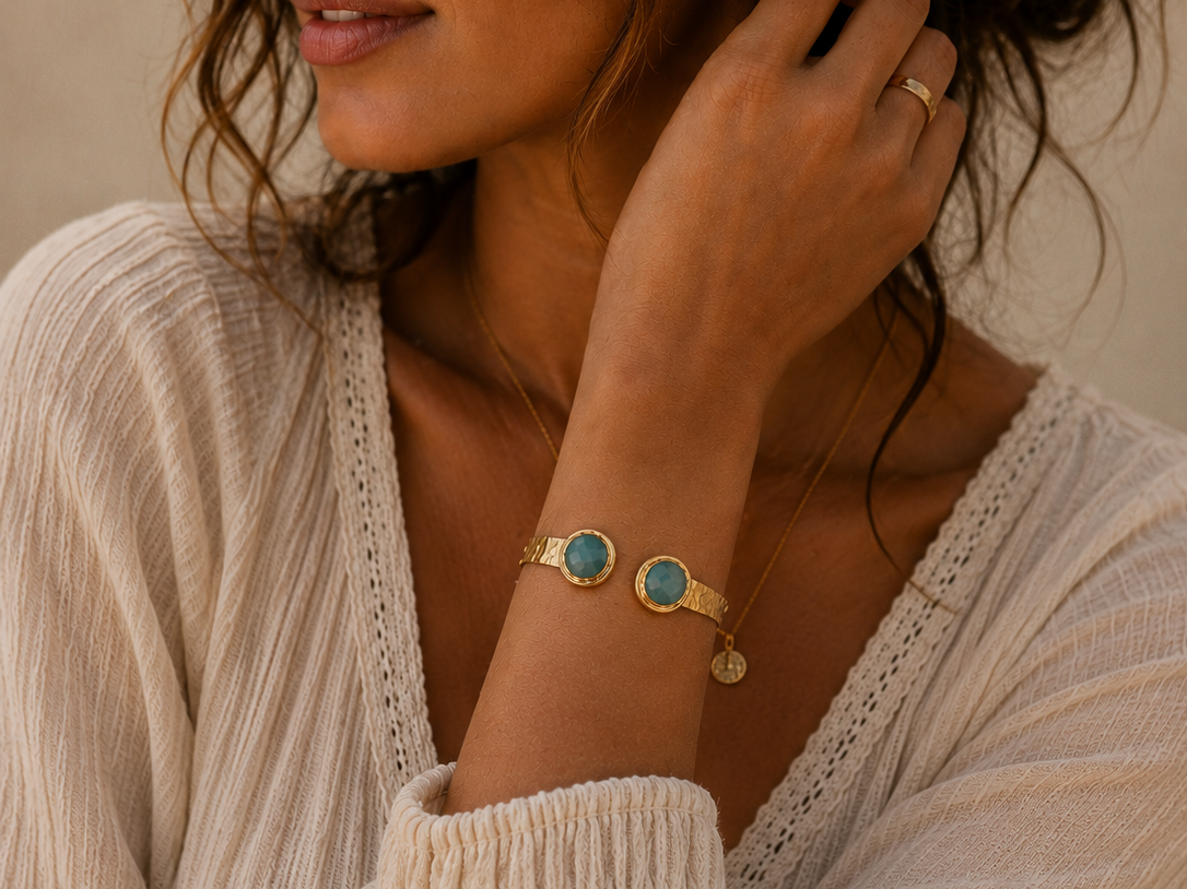 Woman wearing gold and amazonite jewellery with a beige sweater.