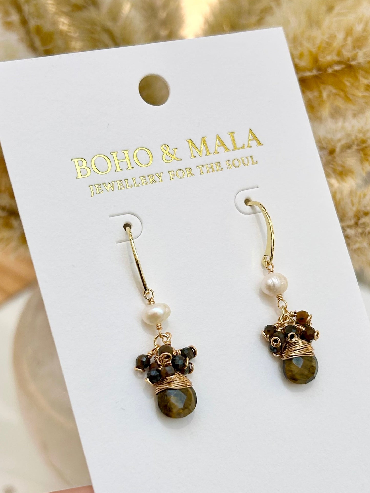 
                  
                    Pair of earrings on a BOHO & MALA branded card with a blurred natural background
                  
                