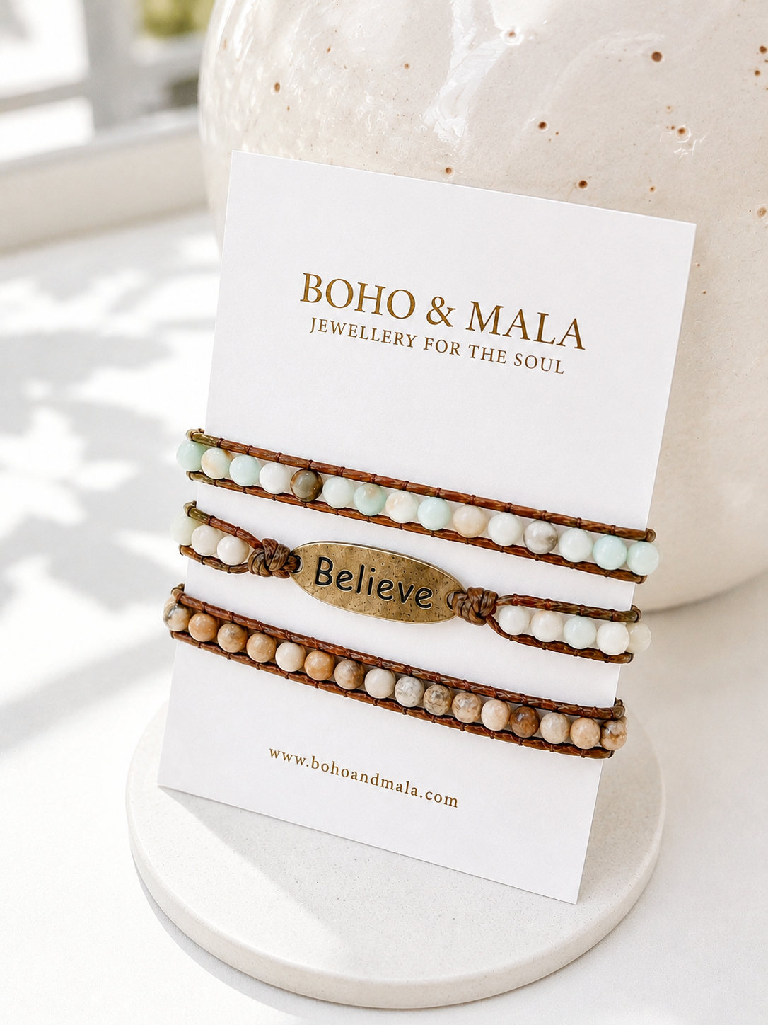 Amazonite believe wrap beaded bracelets on a 'Boho & Mala' branded card with a ceramic jar in the background.
