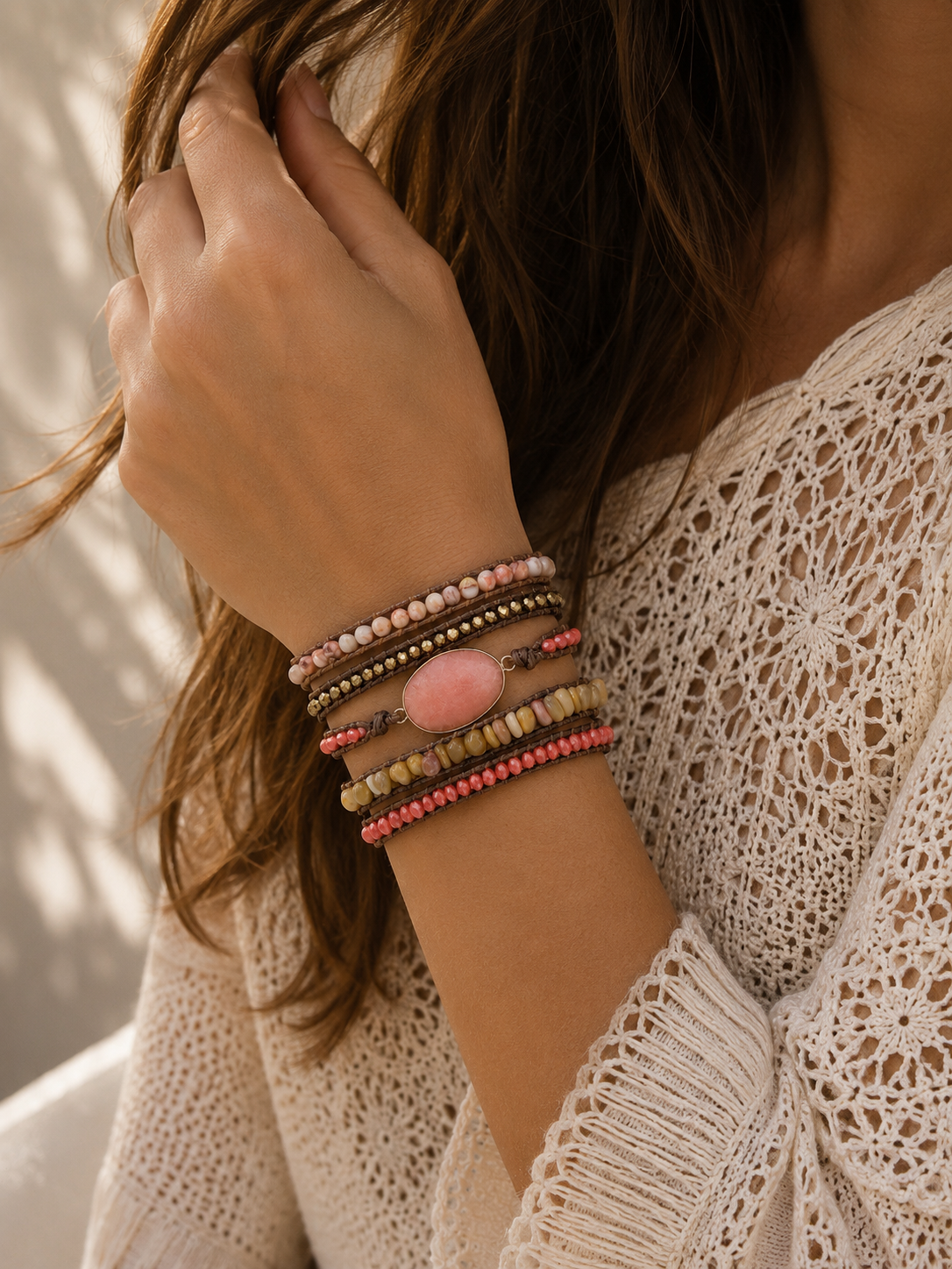 
                  
                    Close-up of a person wearing peach jade mixed wrap bracelets on a blurred background
                  
                