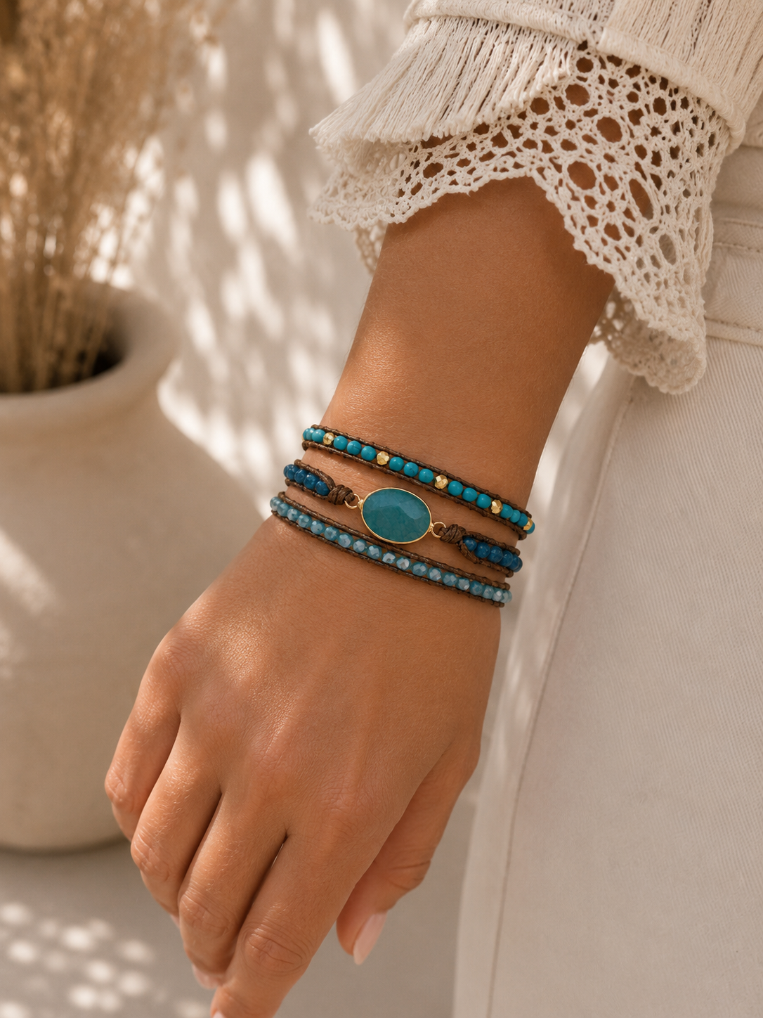 
                  
                    Close-up of a wrist wearing turquoise blue beaded bracelets with a blurred background
                  
                