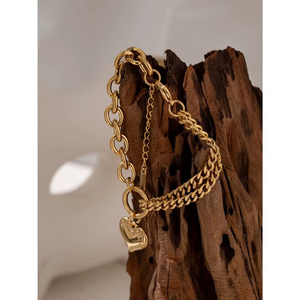 
                  
                    Coeur Gold Heart Chain Bracelet displayed on a white stand
                  
                