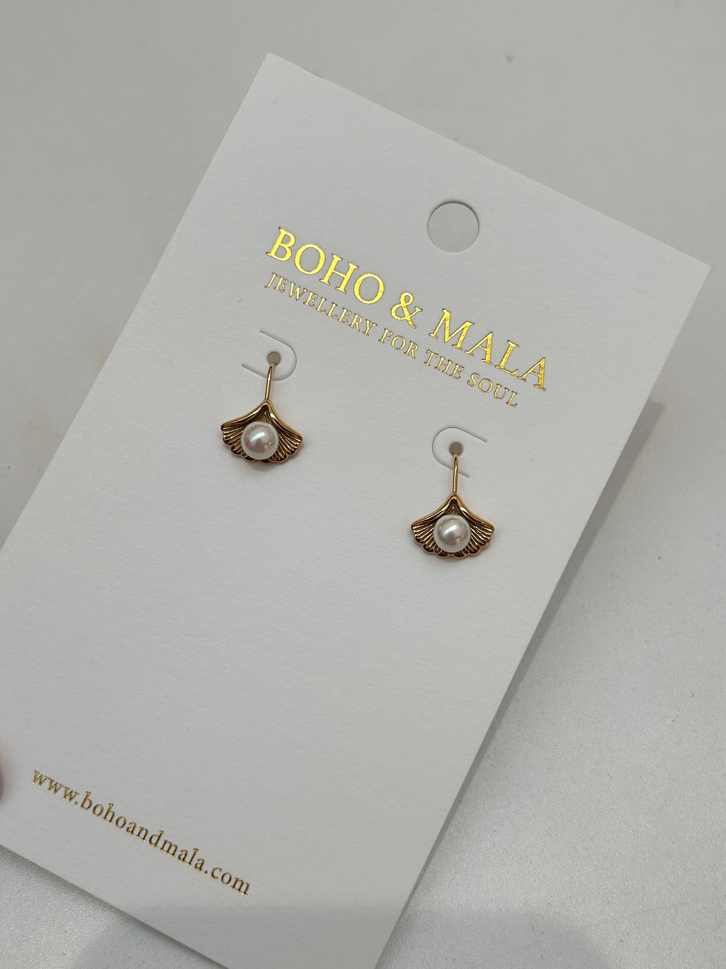 Mira shell fan huggie earrings on Boho & Mala display card