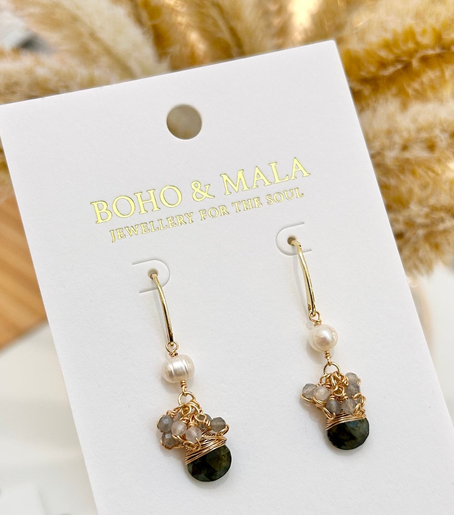 
                  
                    Pair of earrings on a BOHO & MALA branded card with a blurred background
                  
                