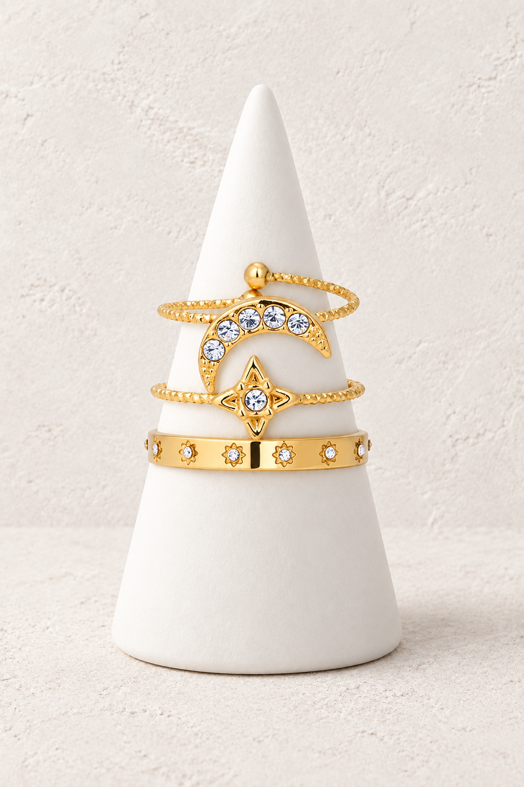 Astrielle Three-Ring Stacker Set on a white display cone against a warm textured background