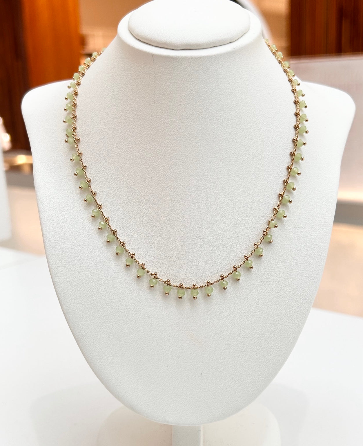 
                  
                    Avelora Prehnite gold-plated gemstone necklace displayed on a jewellery bust
                  
                