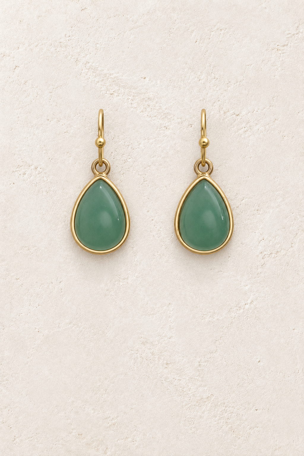 Aviana Green Teardrop Earrings on cream plaster background