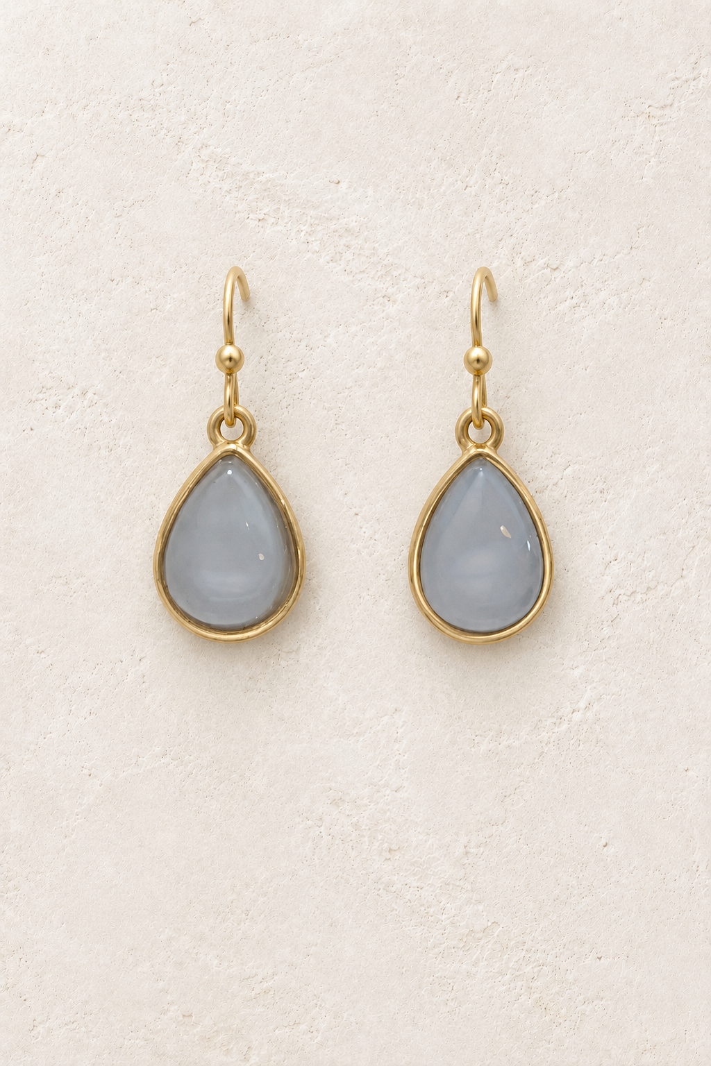 Aviana Grey Teardrop Earrings on cream plaster background