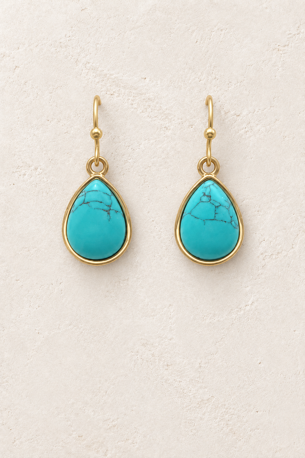 Aviana Turquoise Teardrop Earrings on cream plaster background
