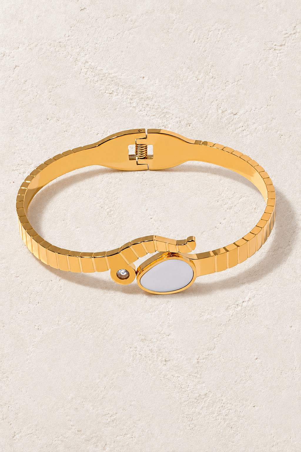 
                  
                    Gold cuff bracelet on ivory textured background
                  
                