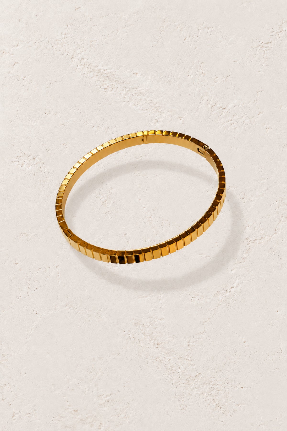 
                  
                    Brisa Mini Gold Ribbed Bangle on Boho & Mala's ivory plaster background
                  
                