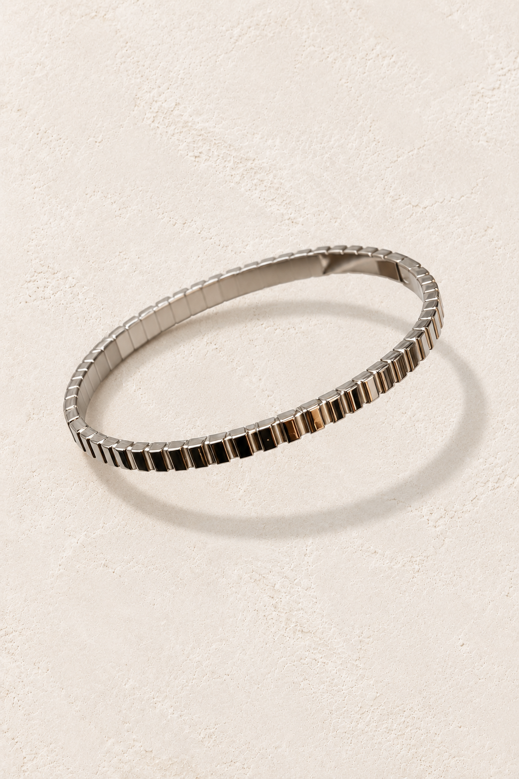 Brisa Mini Silver Ribbed Bangle on cream beige textured background