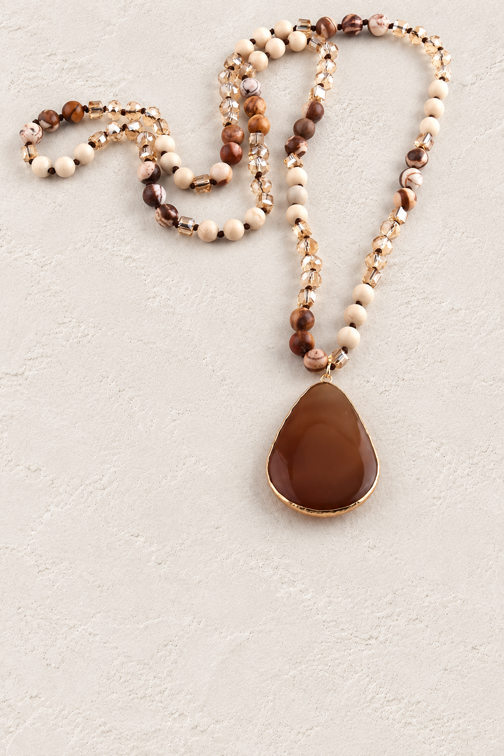 
                  
                    Brown Agate Tribal Necklace on warm ivory plaster background
                  
                