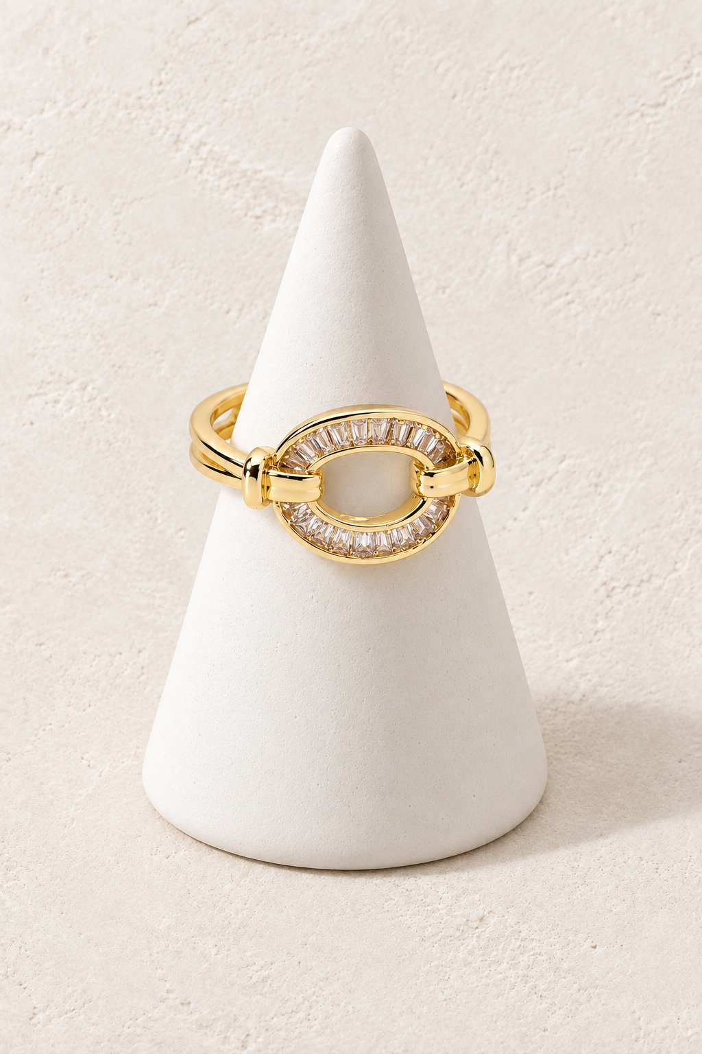 Celestial Link Ring on a white display cone against a warm textured background