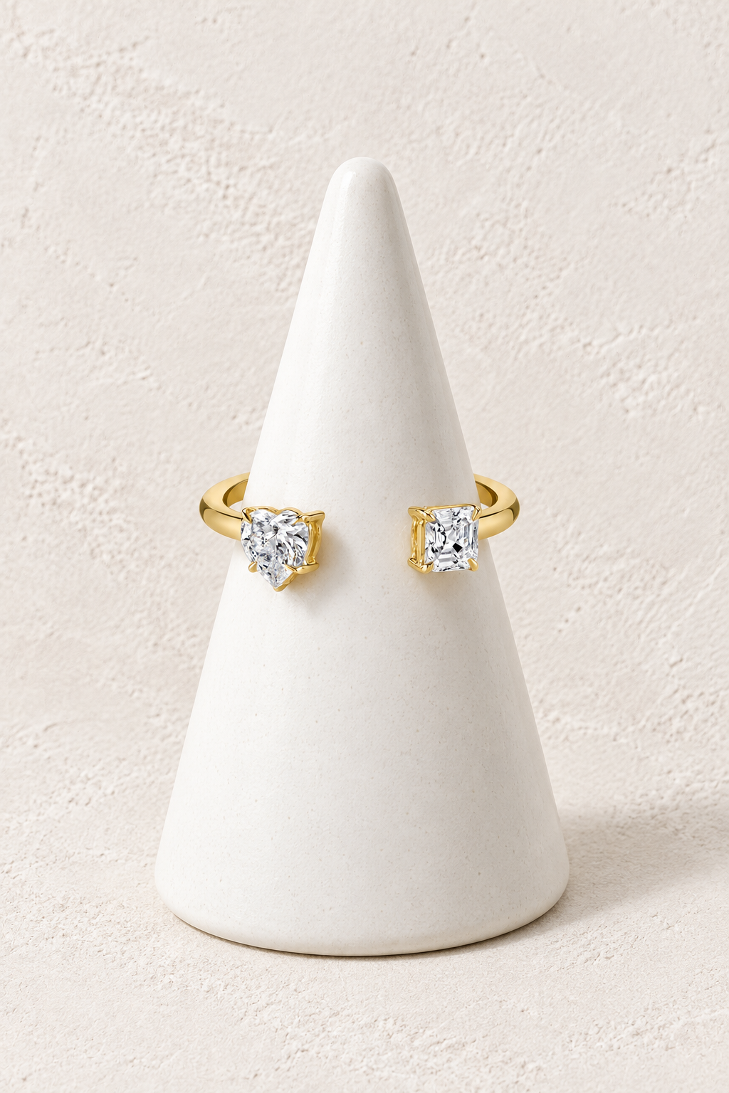 Celine Twin Crystal Ring on a white display cone against a warm textured background