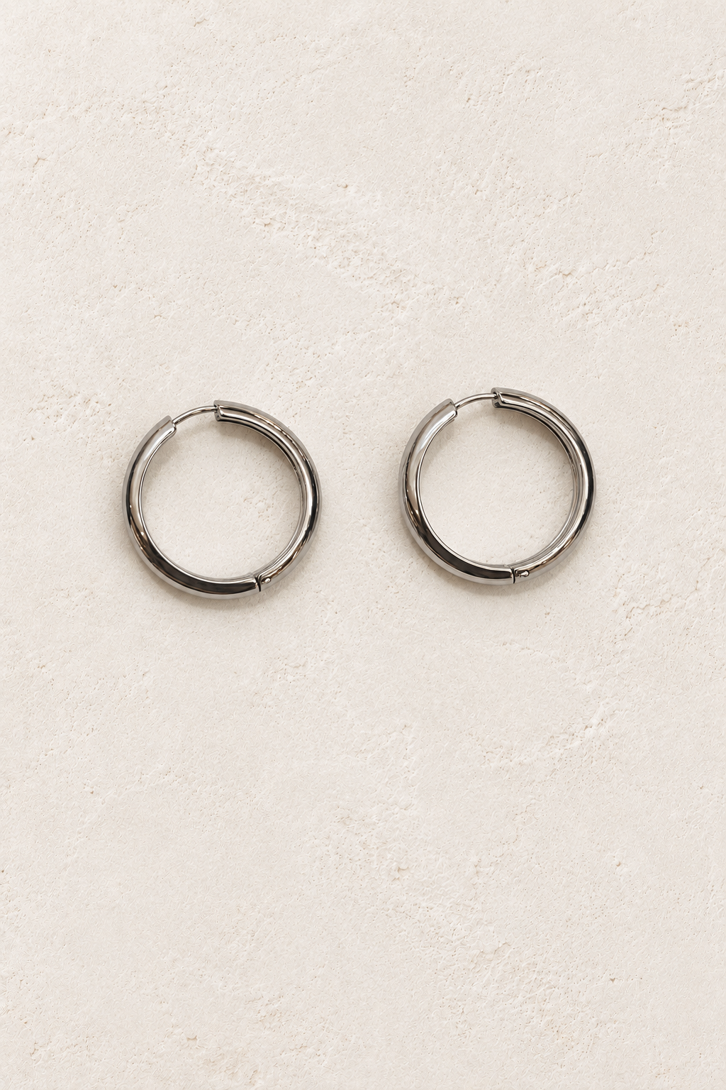 
                  
                    Classic Waterproof Hoop Earrings – Silver 20mm on warm ivory plaster
                  
                
