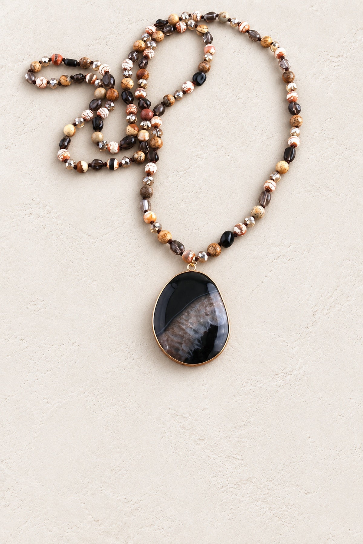
                  
                    Desert Tribal Stone Necklace on warm cream plaster background
                  
                
