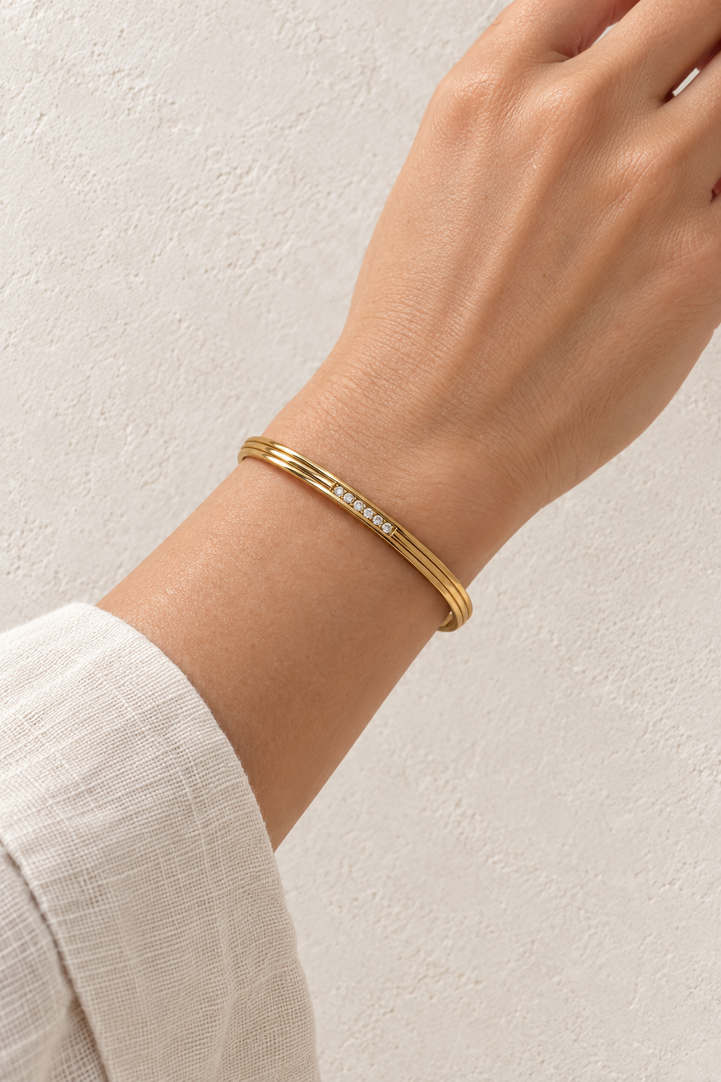 
                  
                    Model wearing Elira Mini Gold Triple Line Crystal Bangle
                  
                