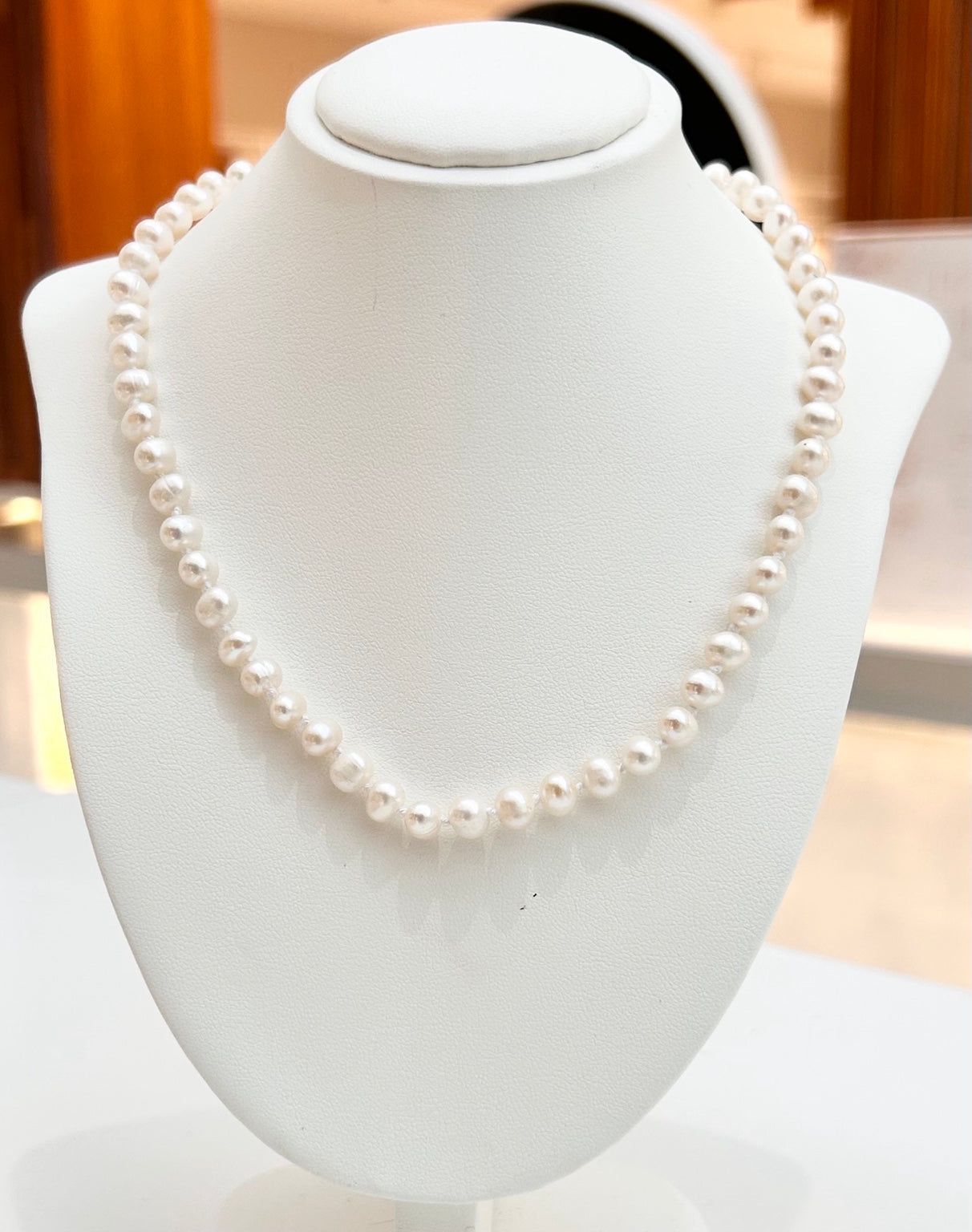 
                  
                    Elodie timeless freshwater pearl strand displayed on a jewellery bust
                  
                
