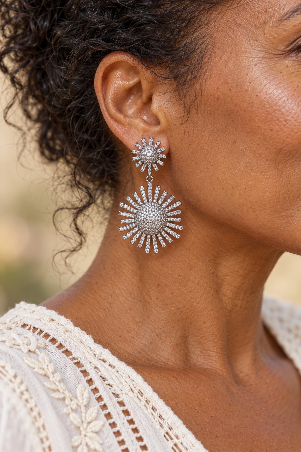 
                  
                    Close-up of Elysia Silver Crystal Stud Drop Earrings – Sparkling Statement Earrings worn on a boho chic model
                  
                