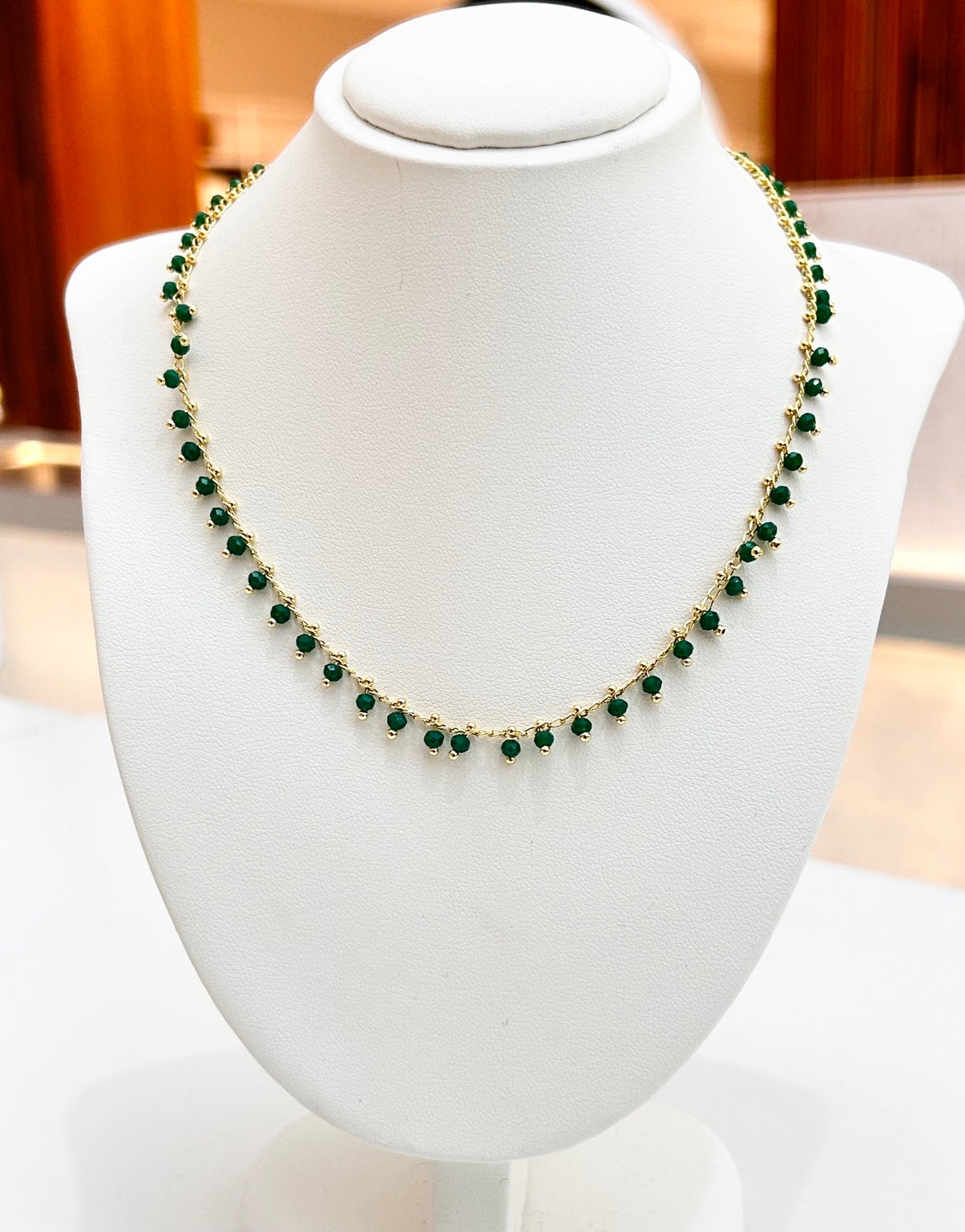 
                  
                    Evora Green Jade gold-plated gemstone necklace displayed on a jewellery bust
                  
                
