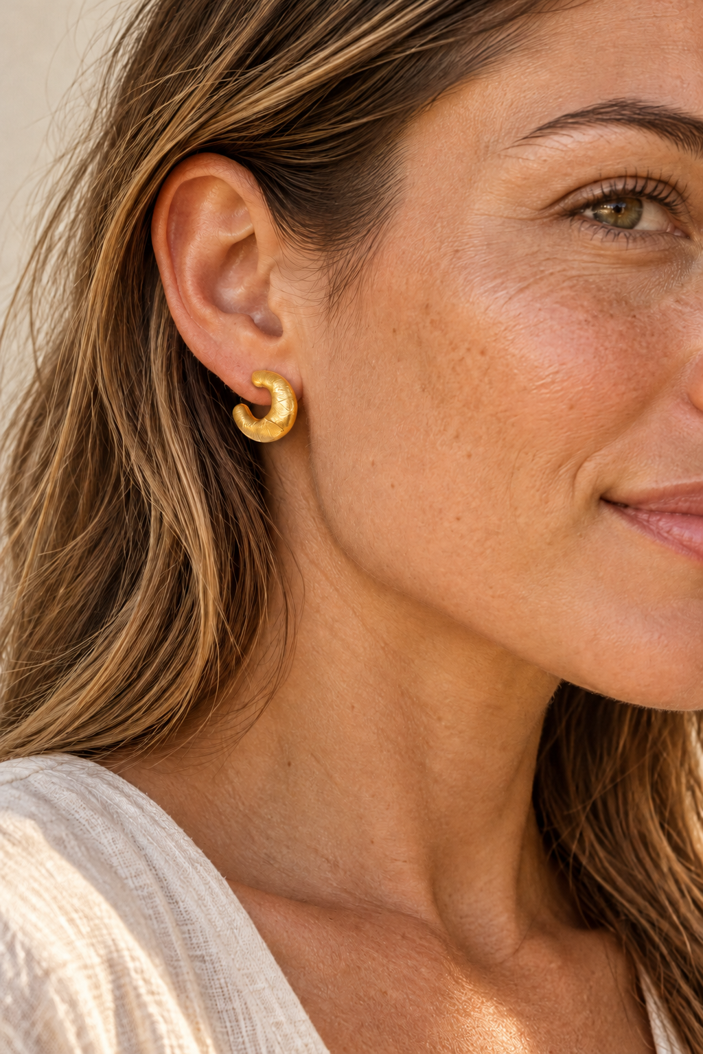 Gold brushed 15mm mini hoop earrings worn on model