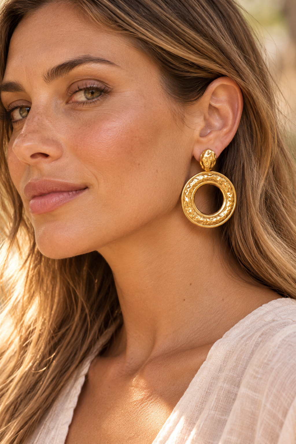 Gold hammered round 55mm drop earrings worn on model