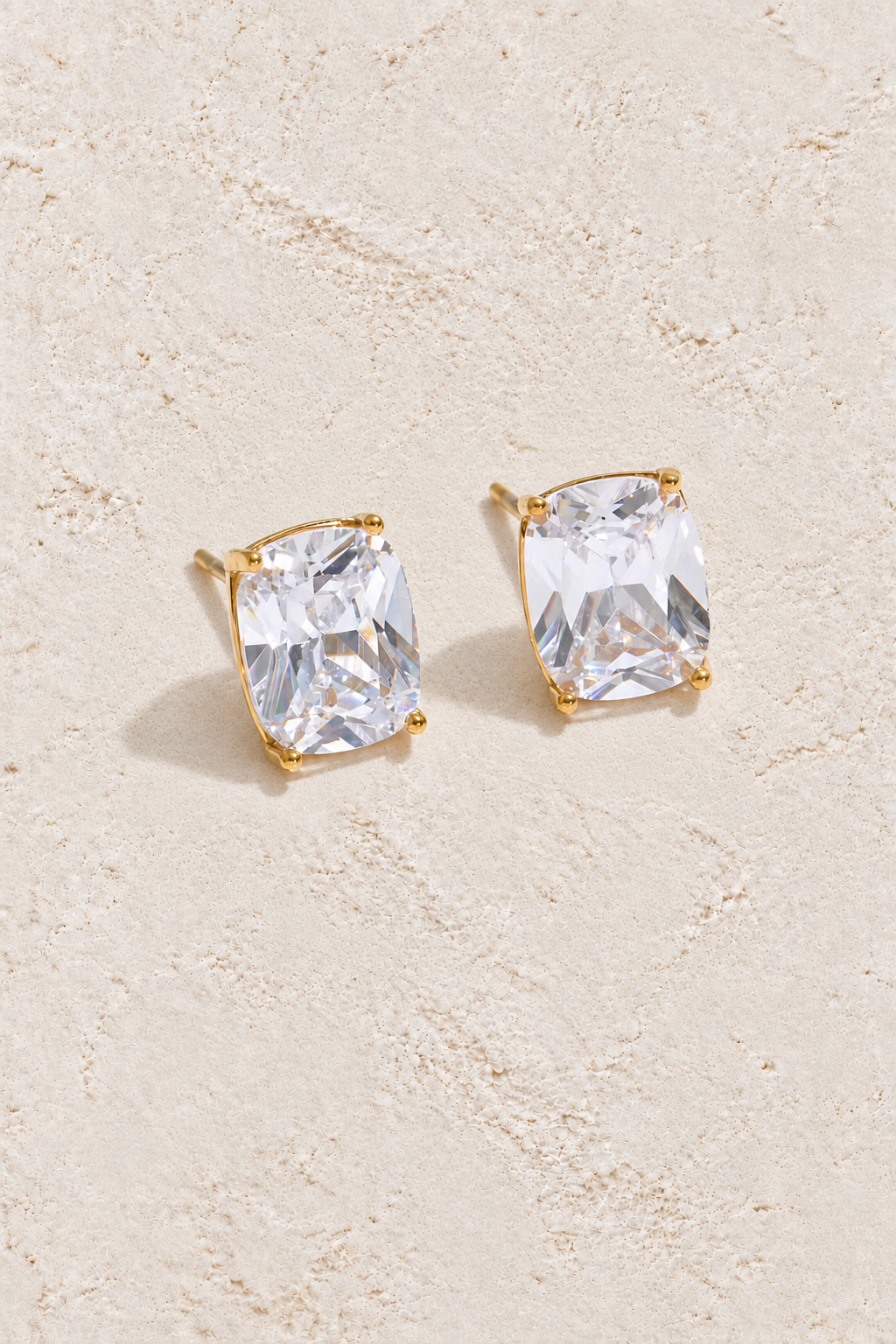 Gold rectangular cubic zirconia studs on cream plaster