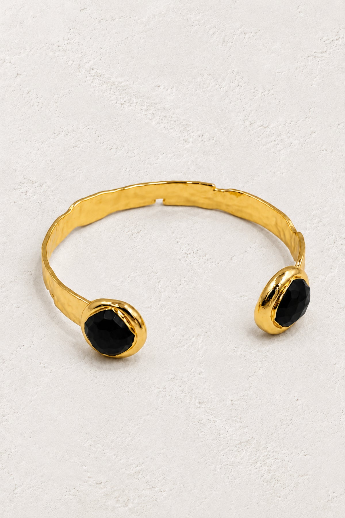 
                  
                    Black Obsidian Isla gold cuff bracelet on ivory plaster
                  
                