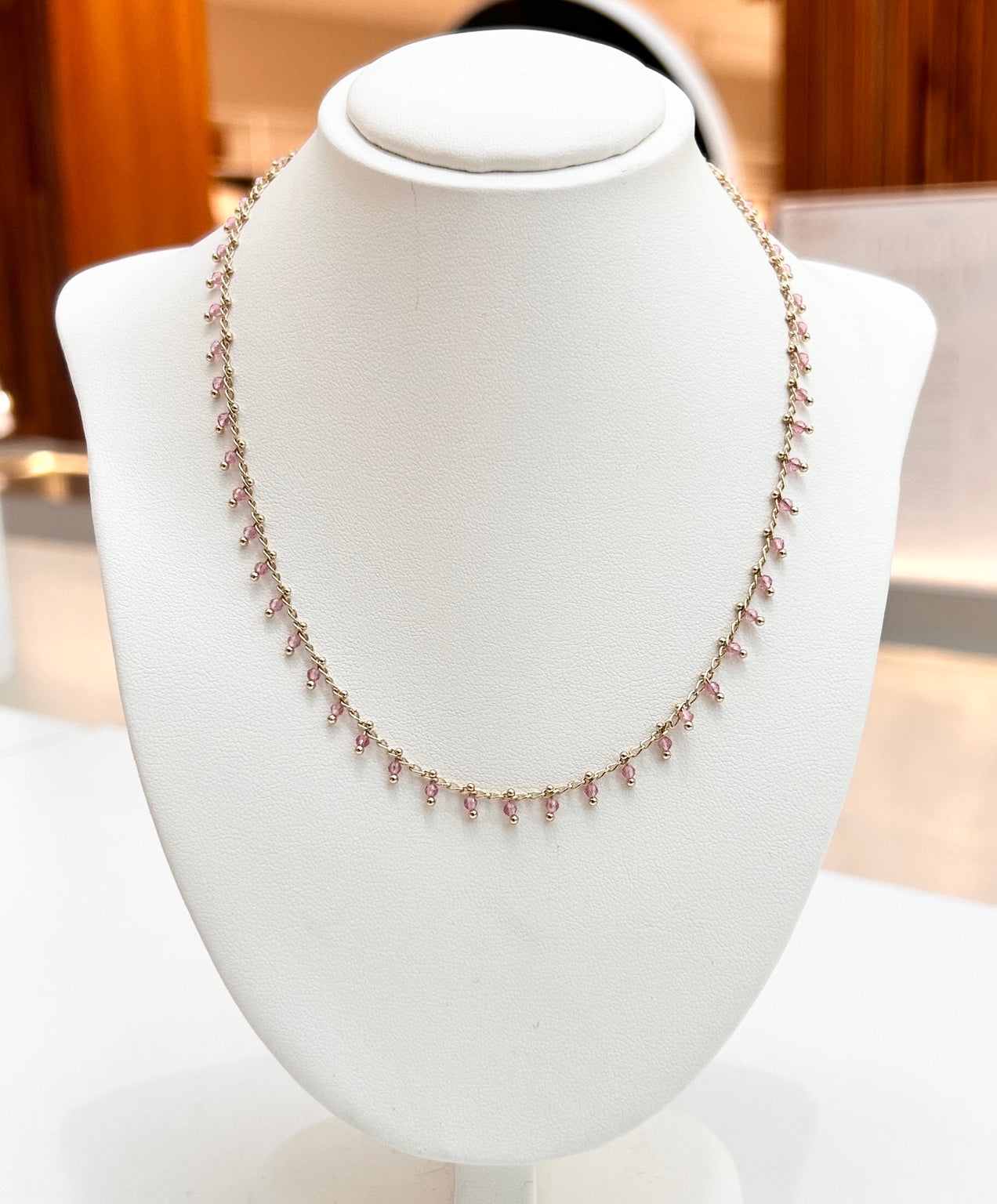 
                  
                    Isolde Rose Quartz gold-plated gemstone necklace displayed on a jewellery bust
                  
                