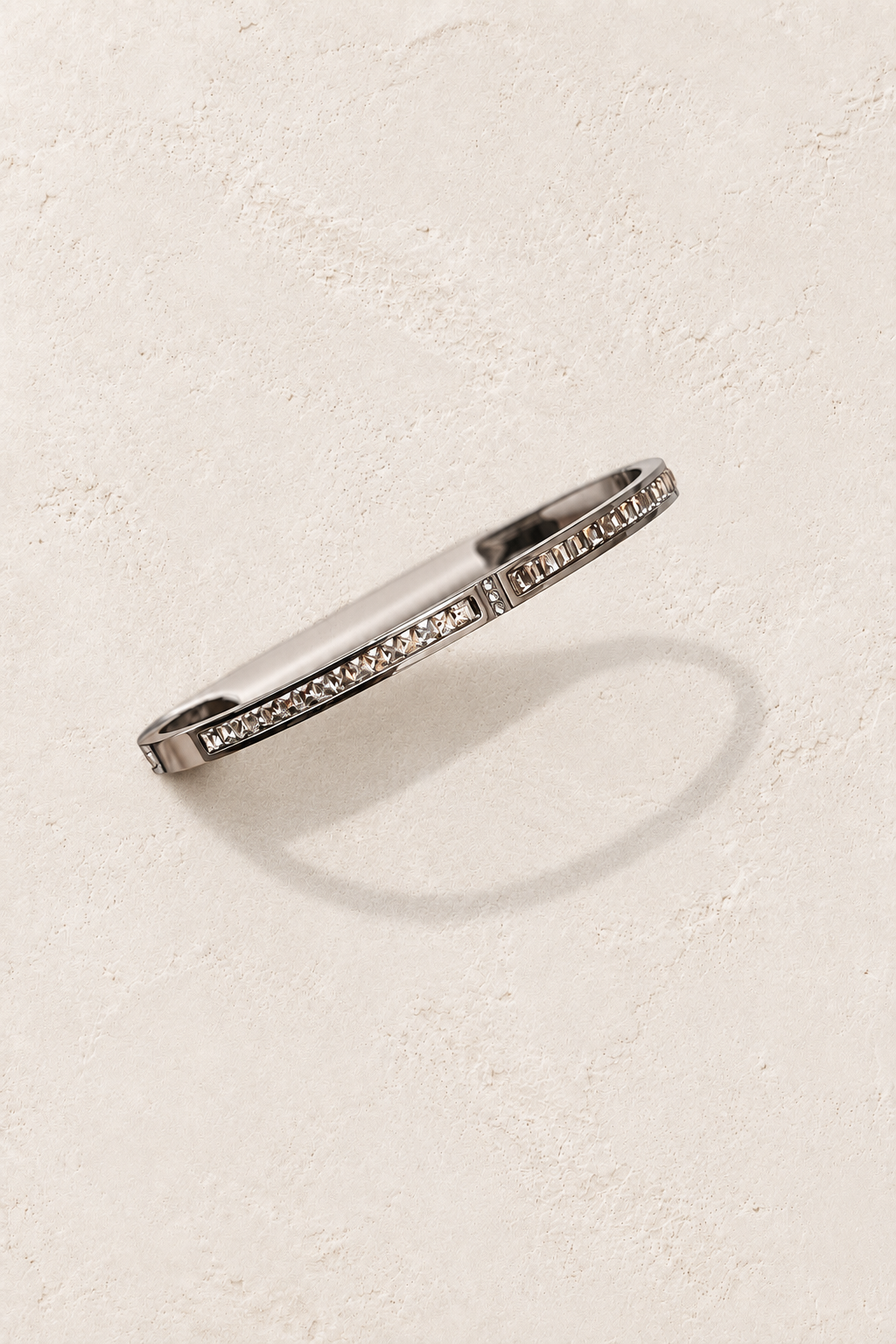 
                  
                    Liora Silver Delicate Crystal Bangle on cream beige textured background
                  
                