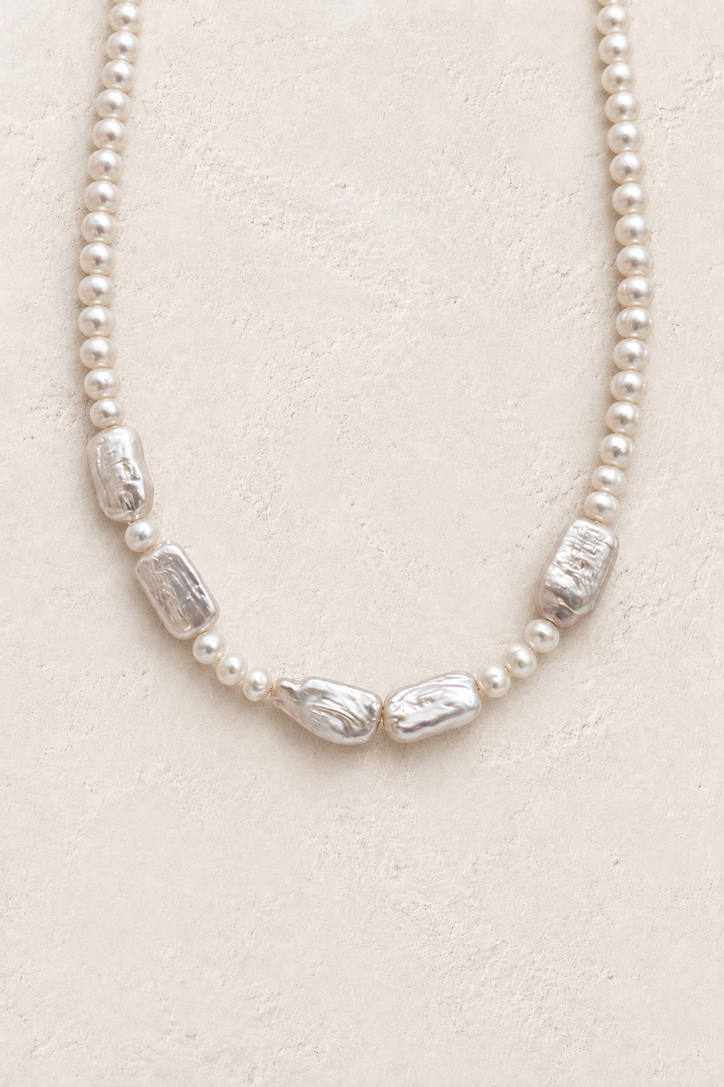 
                  
                    Lucienne statement baroque freshwater pearl necklace on a neutral background
                  
                