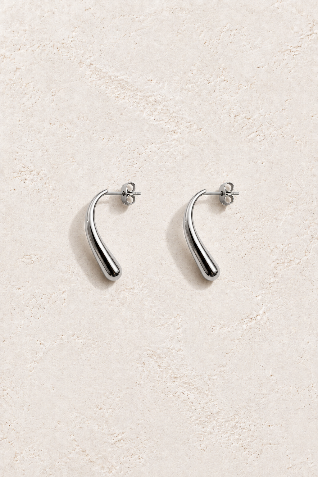 Lune Silver Drop Studs on warm ivory textured background