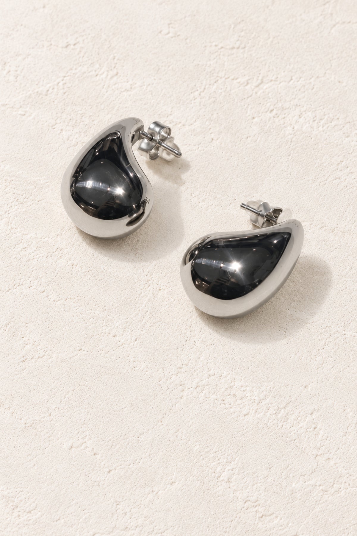 Maelle Silver Dewdrop Stud Earrings on warm ivory plaster