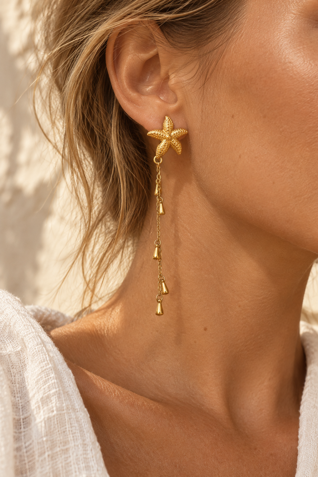Model wearing Marina gold starfish chain earring