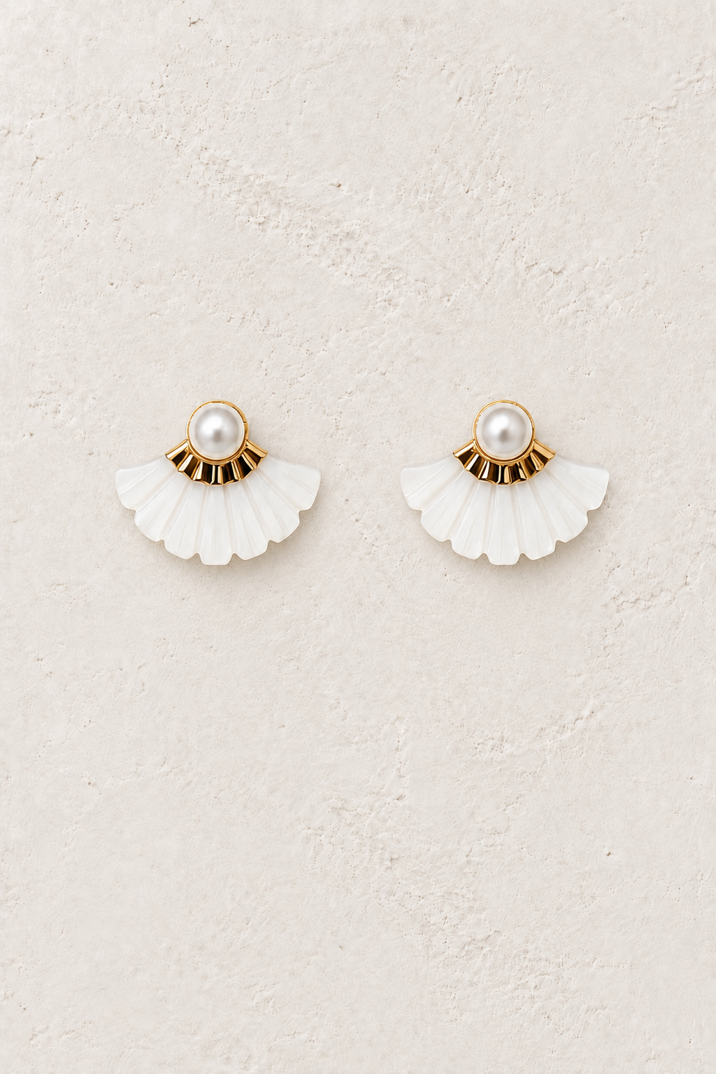 Maris freshwater pearl and shell stud earrings on a warm textured background