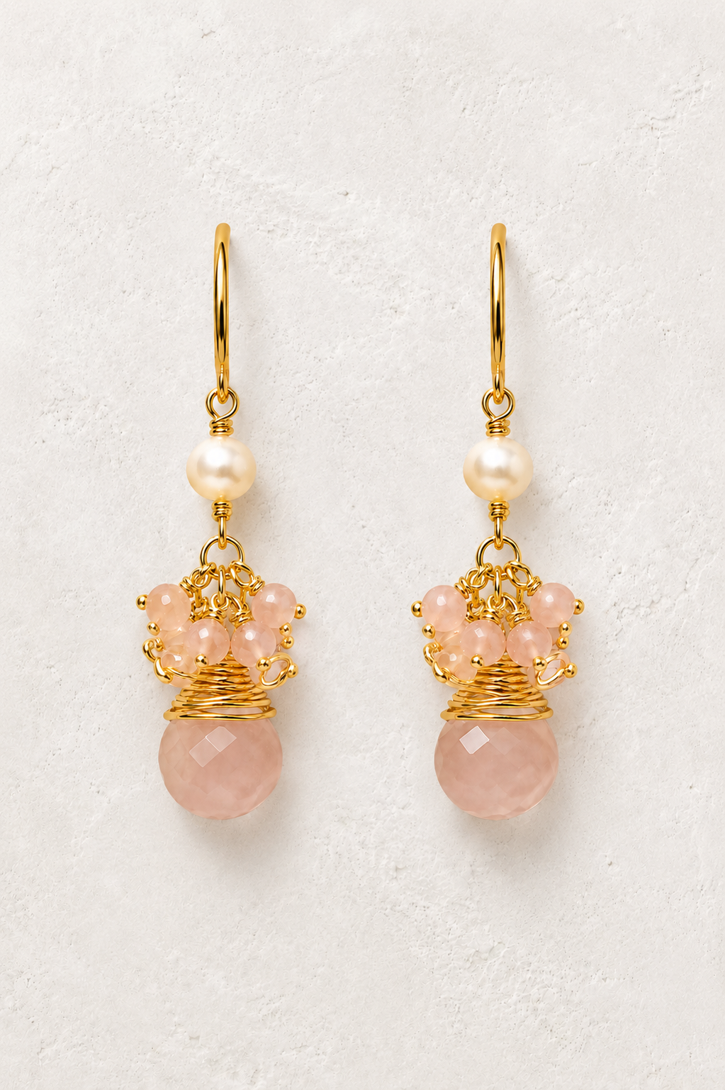 Maris Sunstone genuine gemstone and freshwater pearl earrings on a warm off-white textured plaster background
