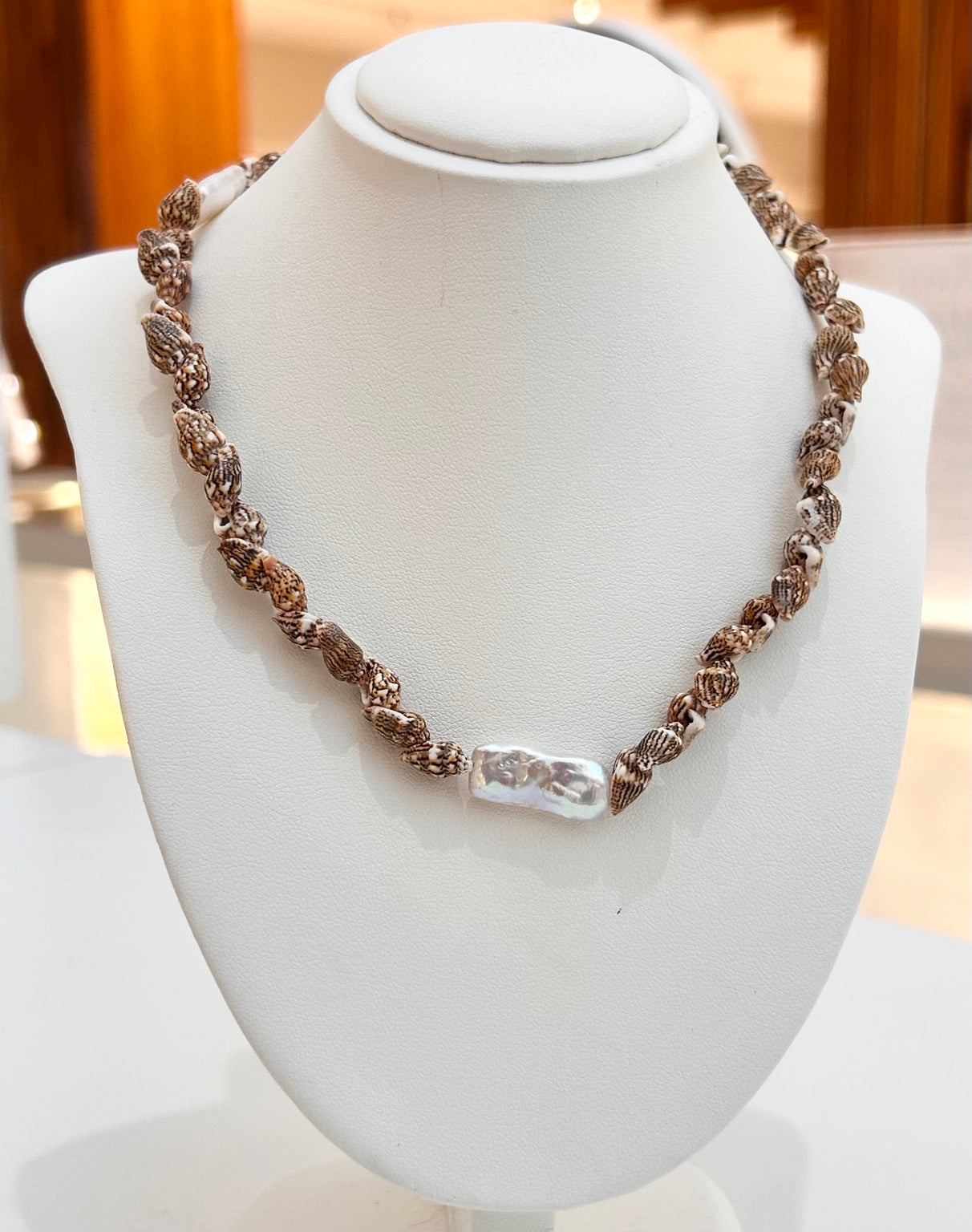 
                  
                    Marisol shell and freshwater pearl necklace displayed on a jewellery bust
                  
                