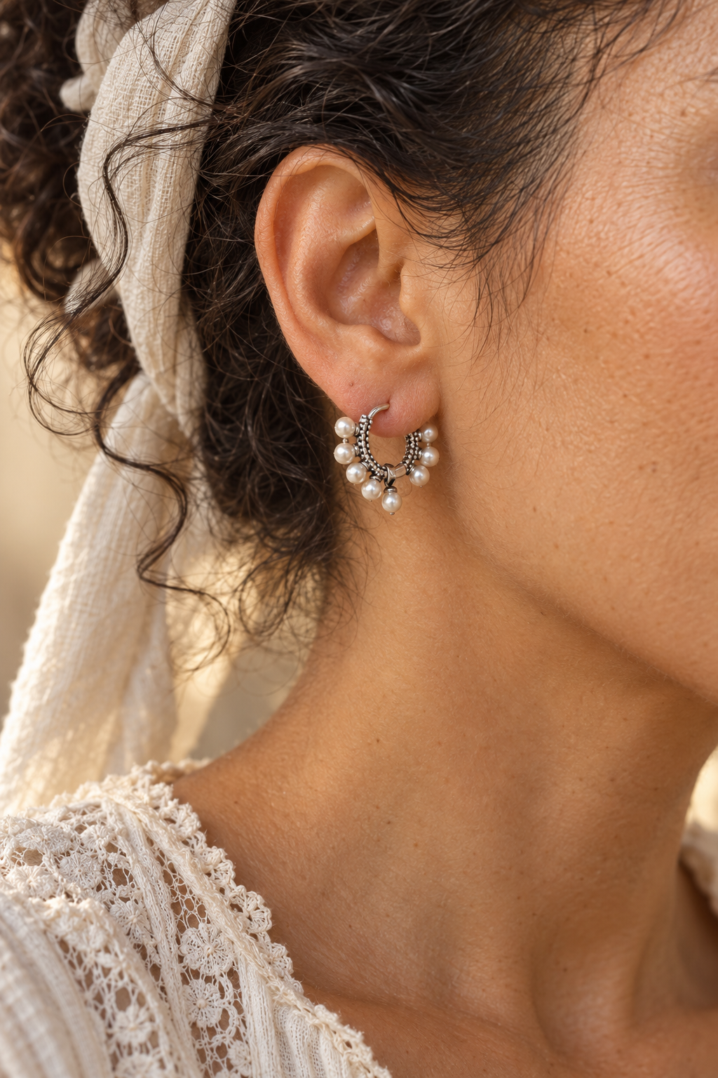 Close-up of Mirelle Silver Pearl Fringe Hoop Earrings worn on a boho chic model