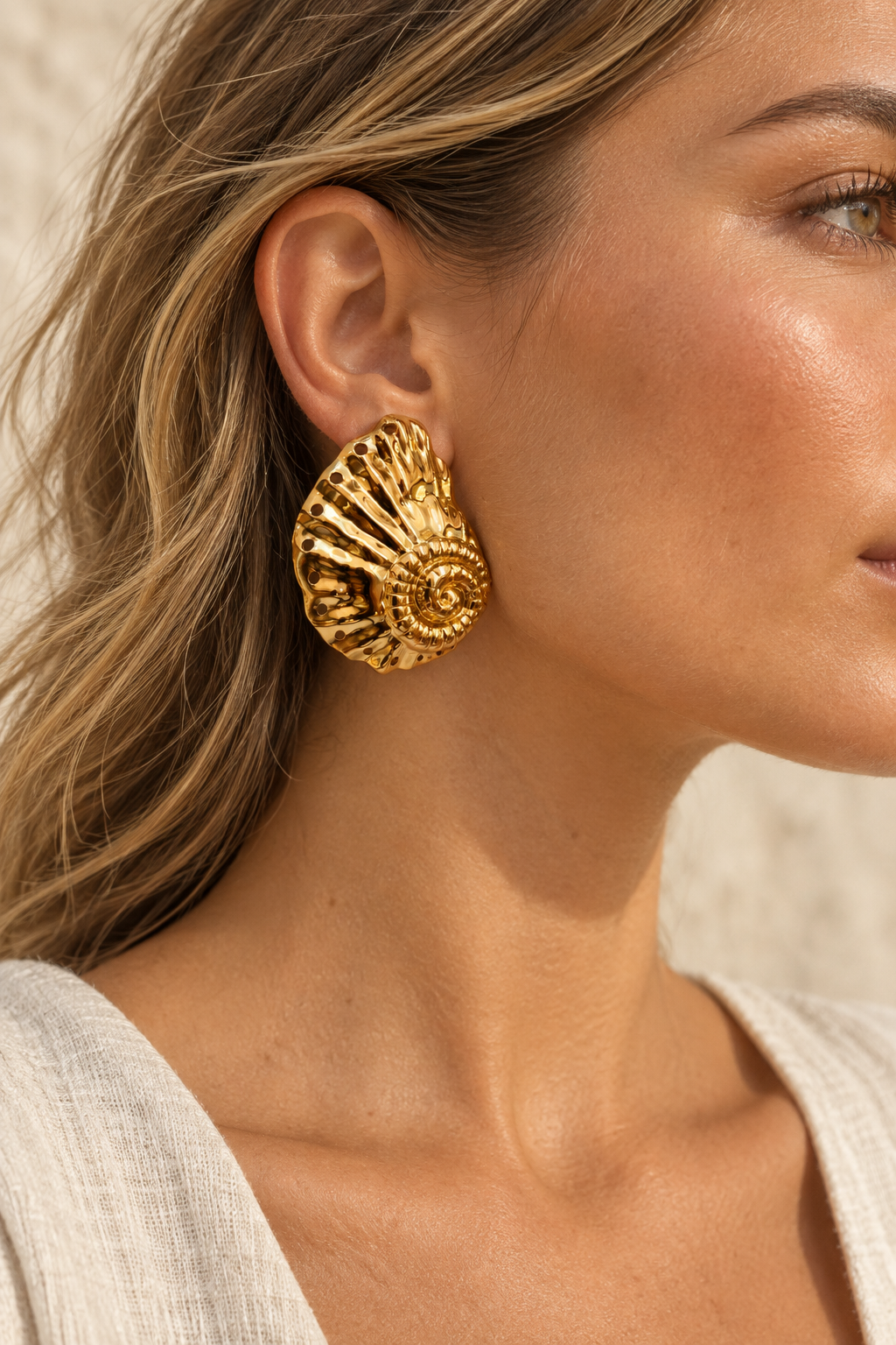 Model wearing Nautilus gold shell statement stud