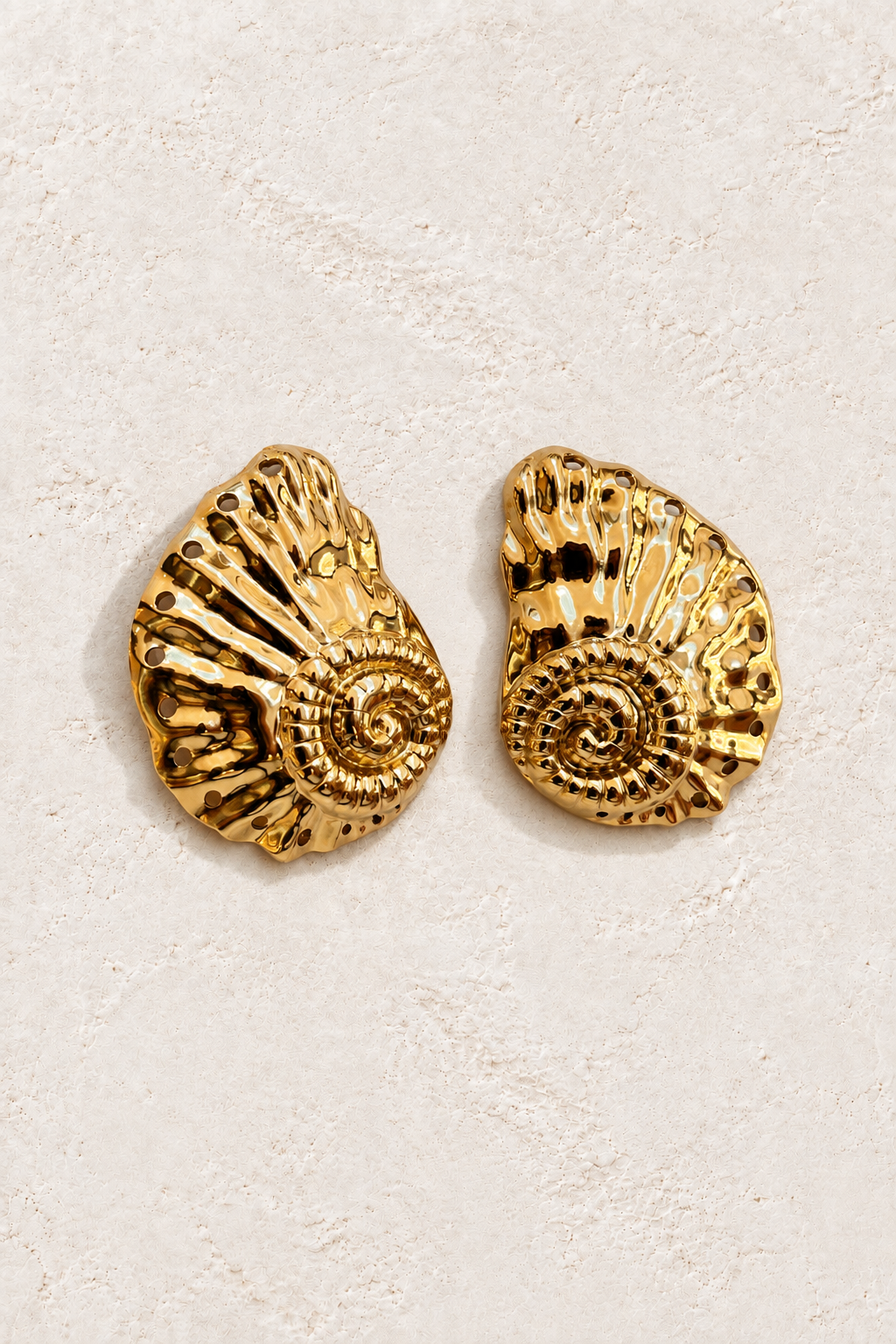 Nautilus Statement Studs on warm ivory textured background