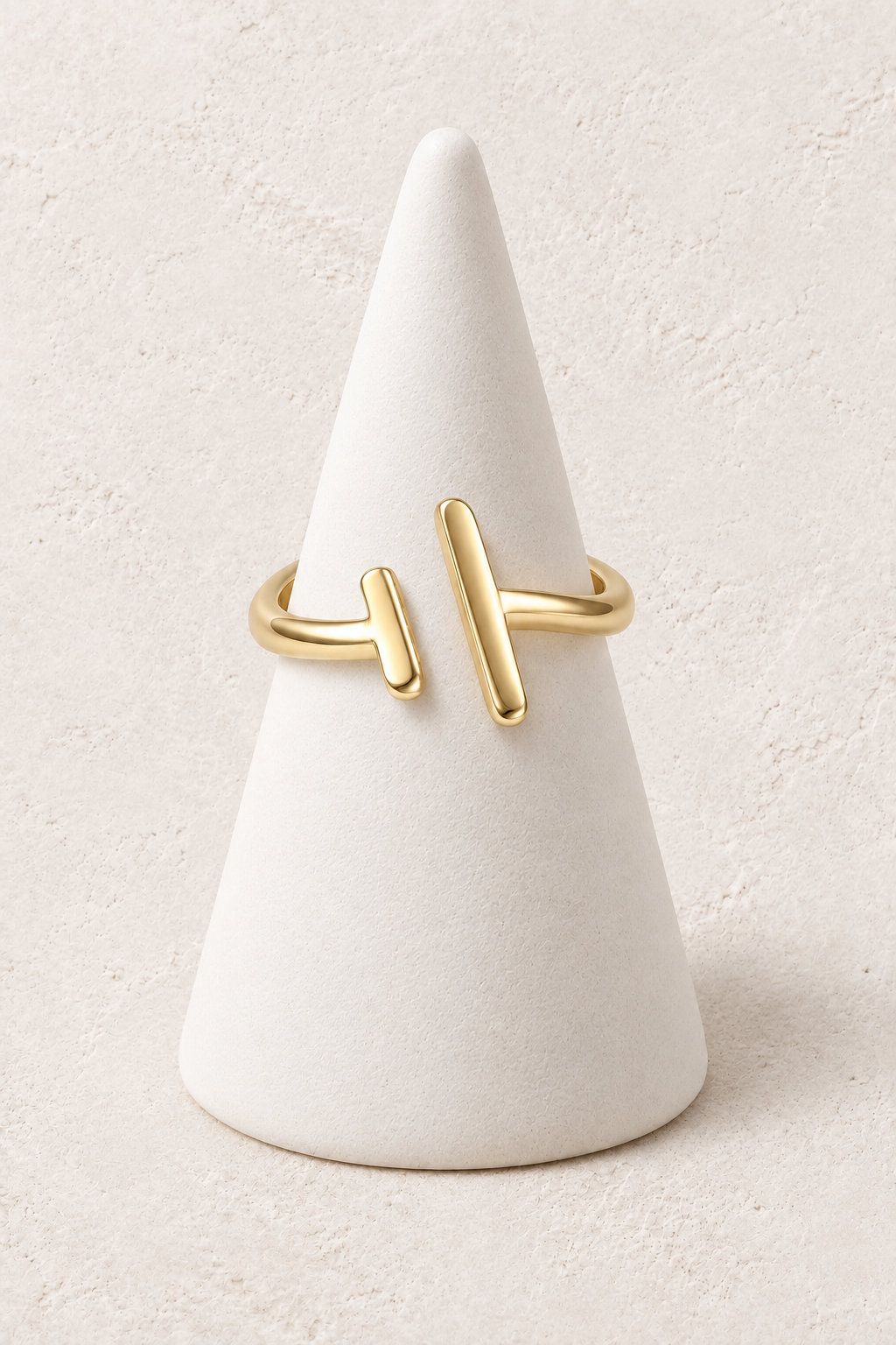 Nerina Sculpted Bar Ring on a white display cone against a warm textured background