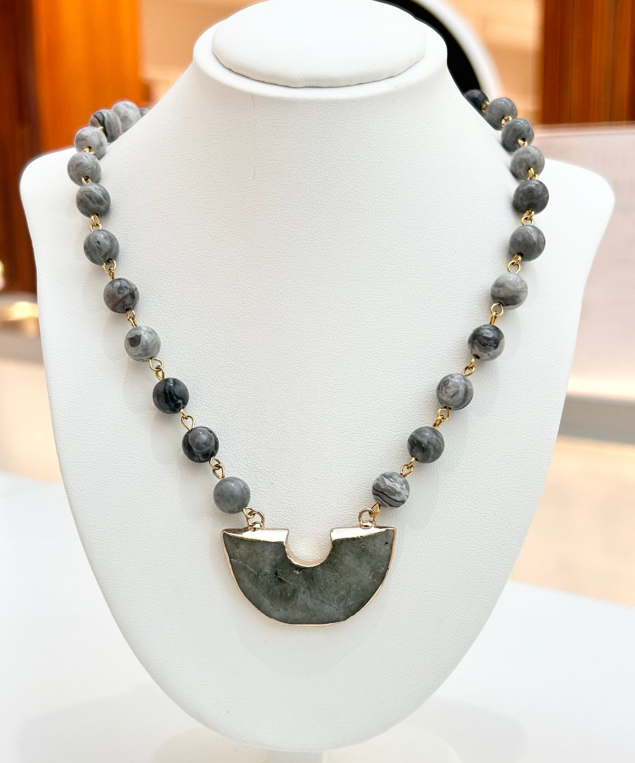 
                  
                    Noctara Labradorite gold-plated statement necklace displayed on a jewellery bust
                  
                