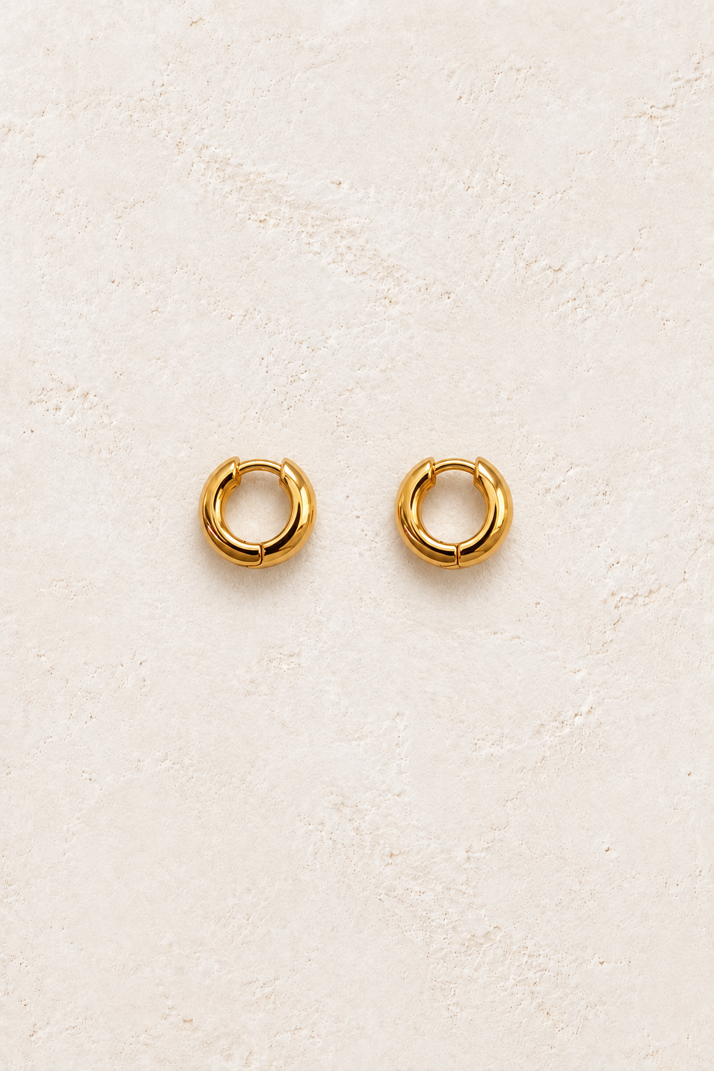 Nola Classic Gold Huggies on warm ivory textured background