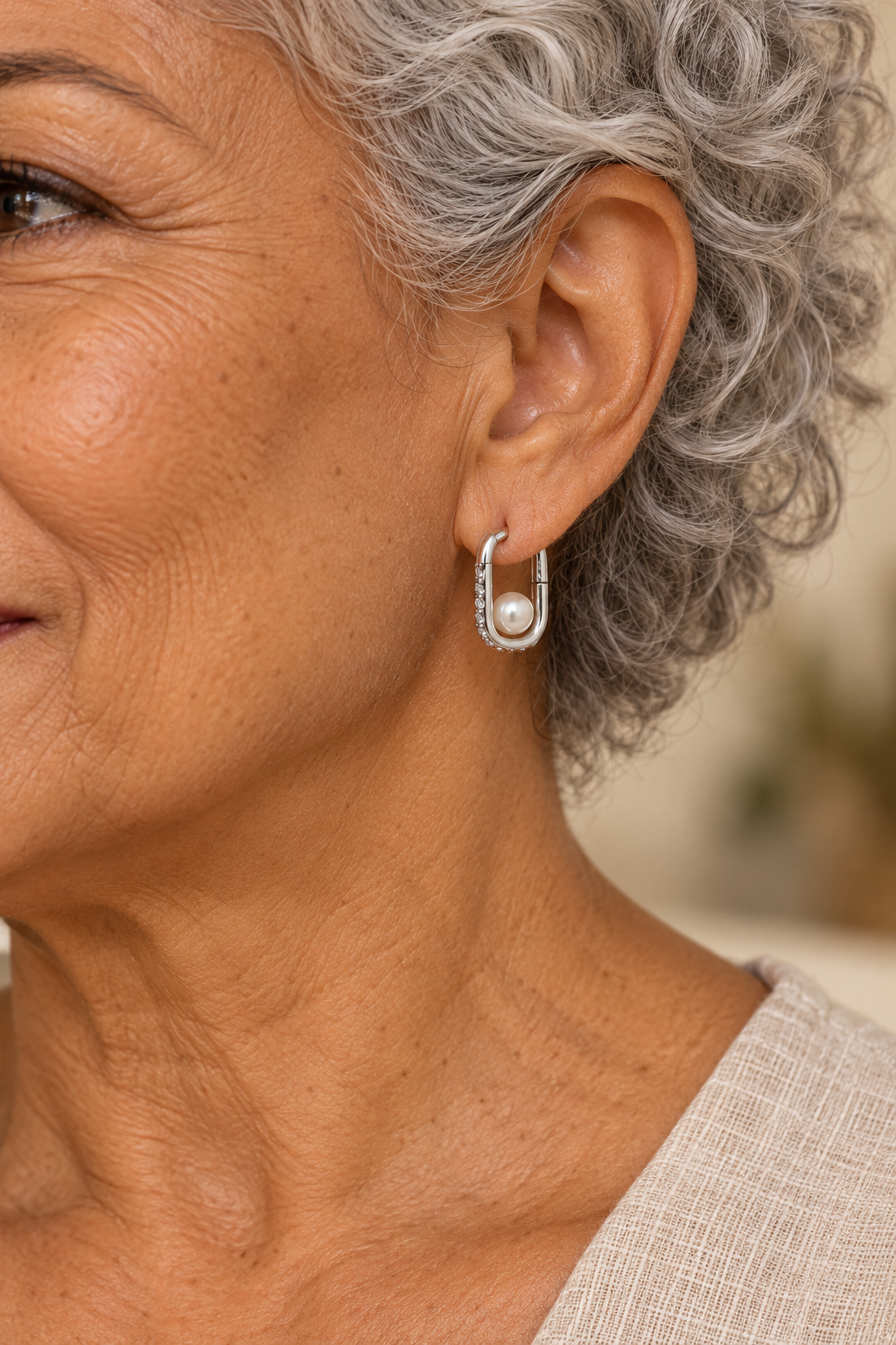 Close-up of Odette Silver Pearl Oval Hoop Earrings worn on a boho chic model