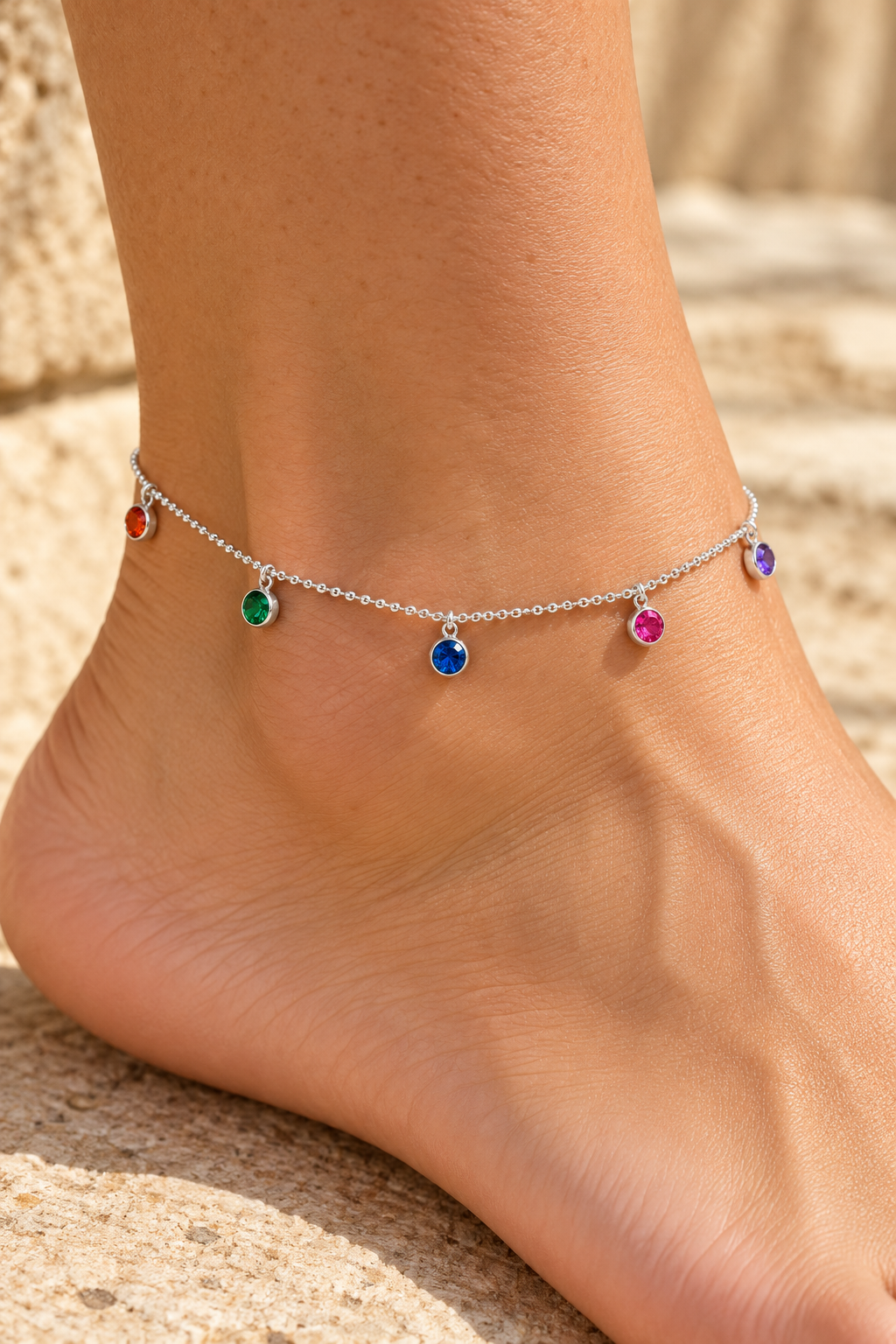
                  
                    Rainbow Crystal Silver Anklet worn on an ankle, with five coloured crystal charms
                  
                