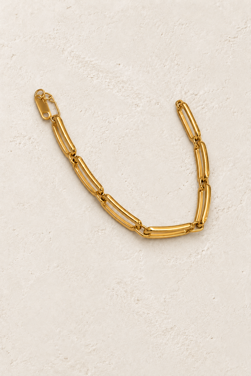 
                  
                    Renata Gold Sculpted Link Bracelet on cream beige textured background
                  
                