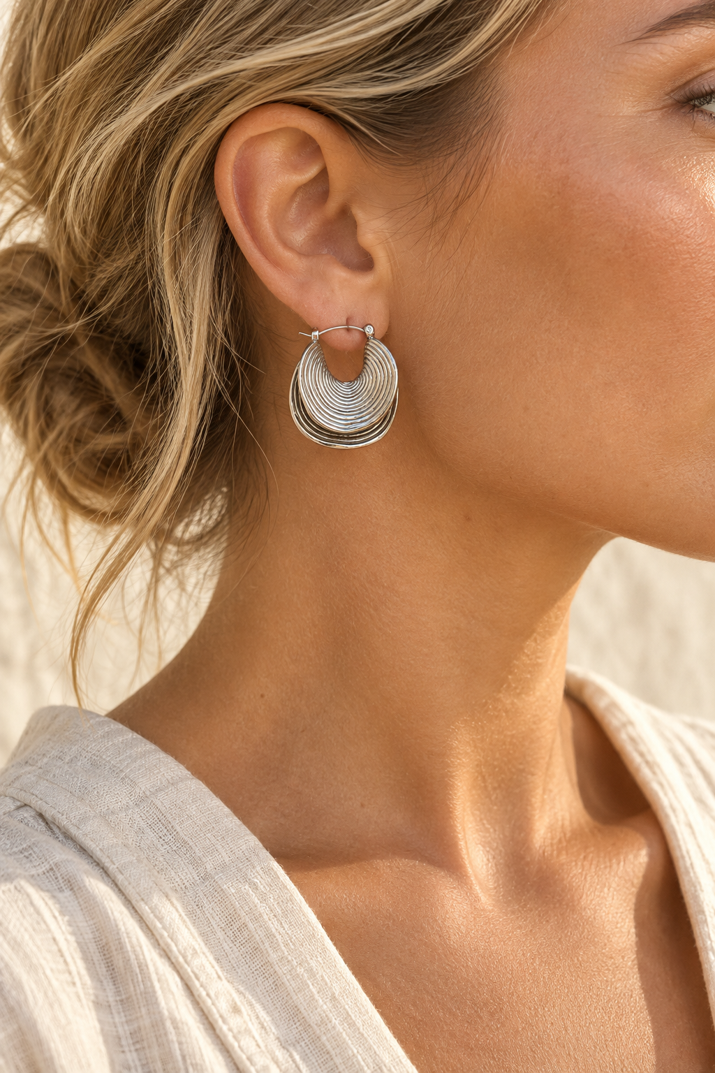 Model wearing Rhea ripple silver hoop earring